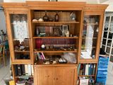 a large wooden cabinet with many books on top of it