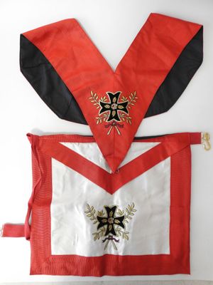 un gros plan sur un tablier rouge et blanc orné d'une croix