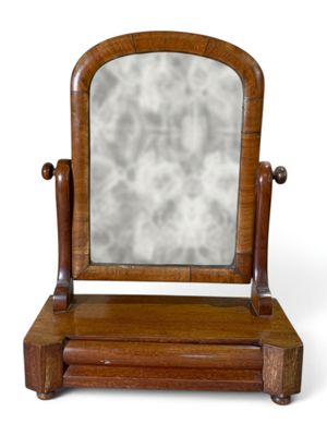un petit miroir posé sur un socle en bois