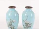 two blue vases with flowers on them on a white surface