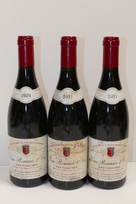 trois bouteilles de vin rouge sont alignées sur une table
