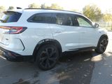 the rear end of a white suv parked in a parking lot