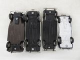 four toy cars sitting side by side on a white surface