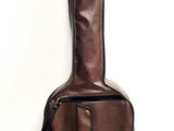 leather guitar case on a white surface with a white wall