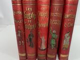 five red books with gold lettering on them sitting on a white surface