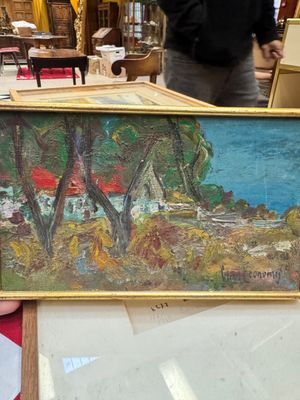 une personne tenant un tableau posé sur une table dans une pièce