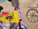 a purple bicycle with a yellow flag on it