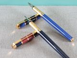 two pens sitting on top of a table next to each other