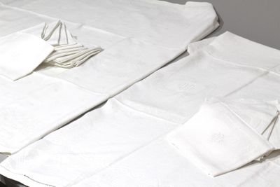 deux serviettes blanches pliées posées sur une table, à côté d'une paire de ciseaux