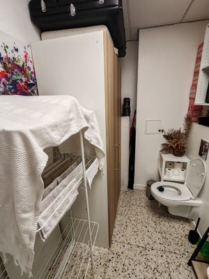 une petite salle de bains avec un lit et des toilettes à l'intérieur