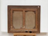painting on a wooden easel with a white wall in the background