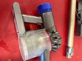 two vacuums and a hose on a red surface