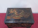 an image of a black and gold decorated box on a red cloth