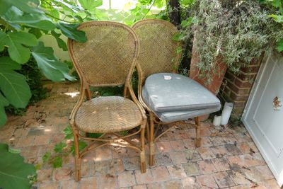 deux chaises en osier placées l'une à côté de l'autre sur une terrasse en briques