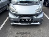 a small silver car parked in a parking lot