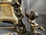 a bronze statue of a boy playing with a clock