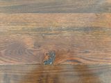 a close up of a wood floor with a hole in it