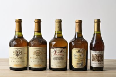 six bottles of wine are lined up on a wooden table
