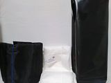 un sac noir et un pantalon blanc posés sur une table