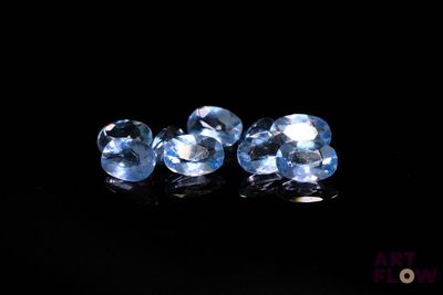 une paire de pierres précieuses de topaze bleue sur un fond noir