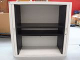 a white cabinet with black shelves in the middle of a room