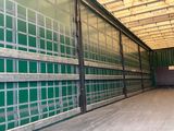un grand conteneur de stockage vert doté de nombreuses fenêtres