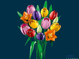brightly colored tulips in a glass vase on a blue background