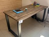 une table en bois sur laquelle est posé un ordinateur portable, dans une pièce