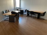 une pièce avec une table, des chaises et une fenêtre
