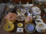 many plates and bowls on a table with a mirror in the background