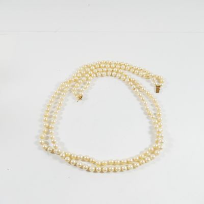 gros plan d'un collier de perles sur une surface blanche