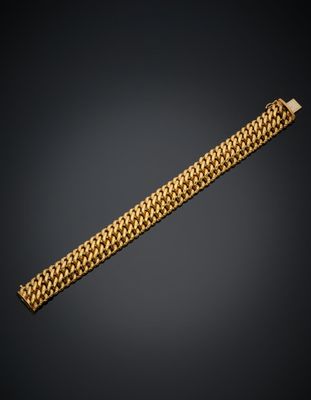 un bracelet en or muni d'un fermoir, sur fond noir