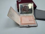 a small compact case with a mirror on top of it