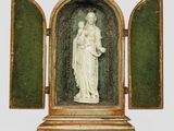 une image représentant une statue d'une femme tenant un enfant dans un coffret vert