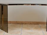 a glass table with a mirror top on a tiled floor