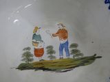 a blue and white plate with a picture of two people on it