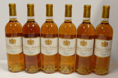 six bouteilles de vin sont alignées sur une surface blanche
