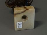 a statue of a bird sitting on top of a marble block