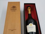une bouteille de vin vide dans une caisse en bois posée sur une surface blanche