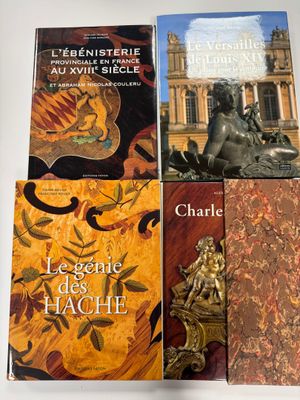 trois livres posés sur une table, devant laquelle se trouve une statue
