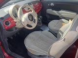the interior of a small red car with the door open