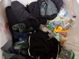 a bag full of clothes and a backpack sitting on a bed