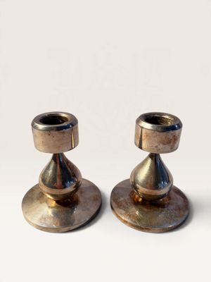 pair of brass candlesticks on a white background