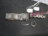a silver bracelet and a pair of earrings sitting on a table