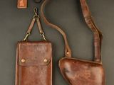 a brown leather case and a brown leather holster on a black background
