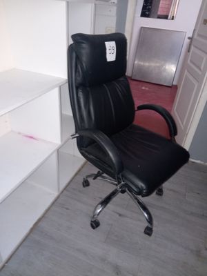 une chaise de bureau noire assise devant un bureau blanc
