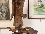 une statue représentant un ange tenant un oiseau sur une branche d'arbre