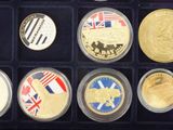 many different coins in a display case on the table