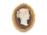 Une broche plaquée or représente le profil d'une femme.