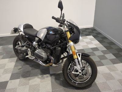 une moto BMW garée sur un sol en carreaux à damier dans une pièce